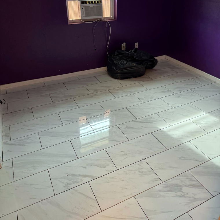 White marble-look porcelain floor tile in a staggered layout across a bedroom with purple walls