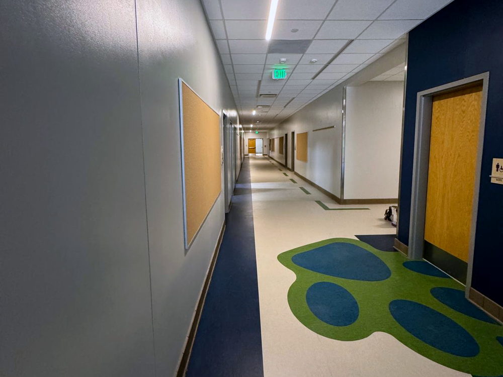 School corridor with resilient sheet flooring, an inlaid paw print graphic and a navy accent wall